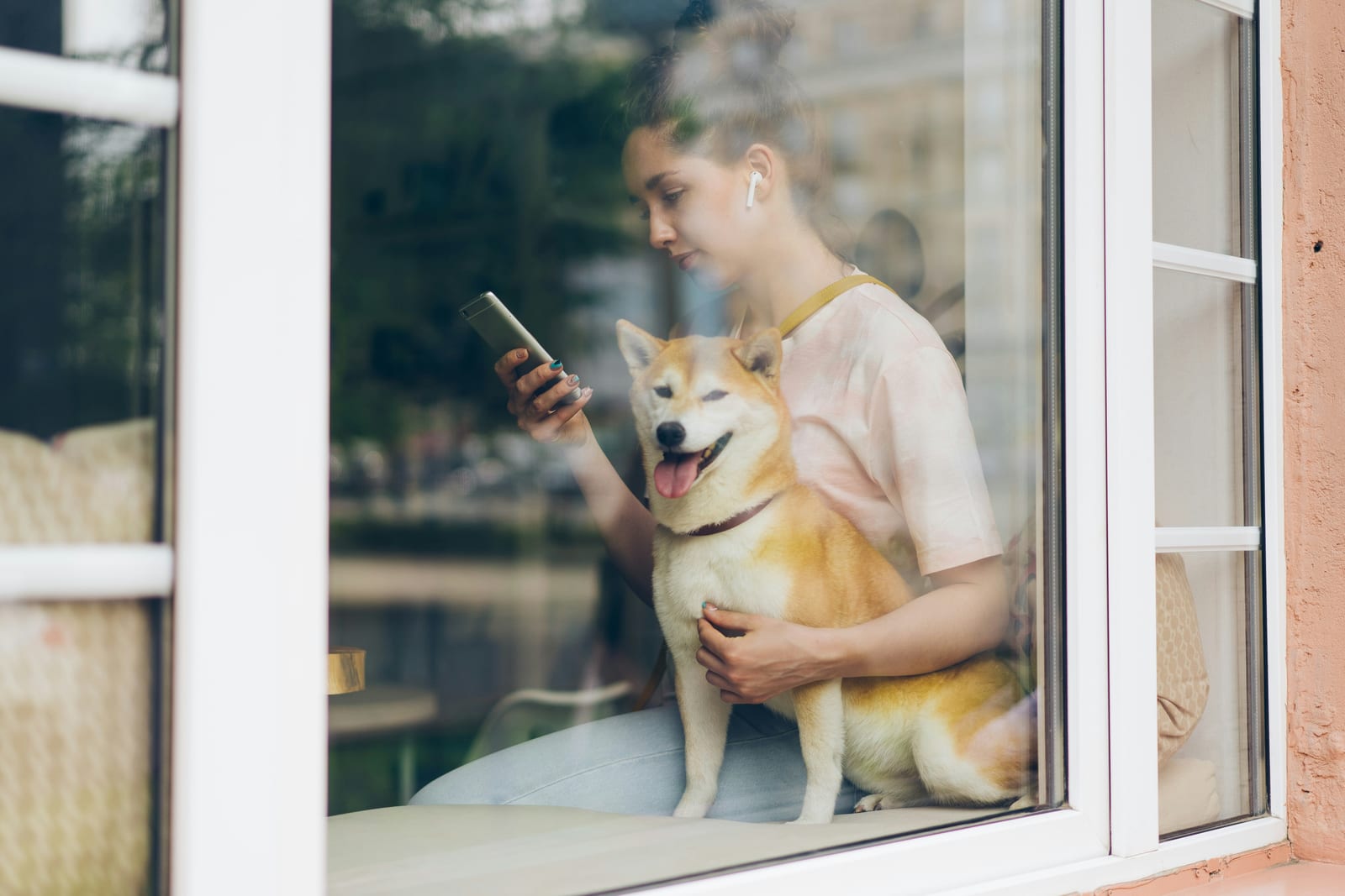 Dueña con su shiba usando el teléfono